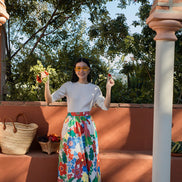 Woman in a colorful floral skirt standing on a terracotta-paved area with greenery in the background
teen textured knit sweater girls