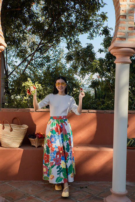 Woman in a colorful floral skirt standing on a terracotta-paved area with greenery in the background
teen textured knit sweater girls